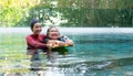 Young trainer helping senior woman in aqua aerobics and working out in the pool. old woman and mature man doing aqua aerobics Royalty Free Stock Photo