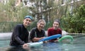 Young trainer helping senior woman in aqua aerobics and working out in the pool. old woman and mature man doing aqua aerobics Royalty Free Stock Photo