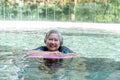 Young trainer helping senior woman in aqua aerobics and working out in the pool. old woman and mature man doing aqua aerobics Royalty Free Stock Photo