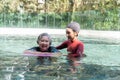 Young trainer helping senior woman in aqua aerobics and working out in the pool. old woman and mature man doing aqua aerobics Royalty Free Stock Photo