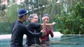 Young trainer helping senior woman in aqua aerobics and working out in the pool. old woman and mature man doing aqua aerobics Royalty Free Stock Photo