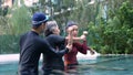 Young trainer helping senior woman in aqua aerobics and working out in the pool. old woman and mature man doing aqua aerobics Royalty Free Stock Photo