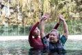 Young trainer helping senior woman in aqua aerobics and working out in the pool. old woman and mature man doing aqua aerobics Royalty Free Stock Photo