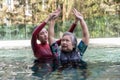 Young trainer helping senior woman in aqua aerobics and working out in the pool. old woman and mature man doing aqua aerobics Royalty Free Stock Photo