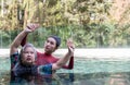 Young trainer helping senior woman in aqua aerobics and working out in the pool. old woman and mature man doing aqua aerobics Royalty Free Stock Photo