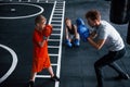 Young trainer teaches kids boxing sport in the gym