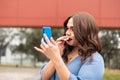 Young trans woman removing make up and using cellphone as mirror. LGTB lifestyle concept. Royalty Free Stock Photo