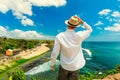 Traveler hiker on top of mountain cliff on background tropical beach Bali, Indonesia Royalty Free Stock Photo