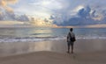 young travel man standing alone on the beach and looks at the sunset in phang-nga thailand.