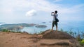 Young travel man standing take a photo with smartphone and see beautiful scenery landscape nature view on rock mountain in phuket Royalty Free Stock Photo