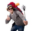 Young traveler backpacker taking selfie photo with stick carrying backpack ready for adventure Royalty Free Stock Photo