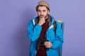 Young traveler caucasian man being confused, feels doubtful and unsure, posing against blue wall with backpack and binocular, Royalty Free Stock Photo