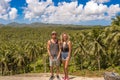 Young traveler couple enjoying on beautiful coconut palms plantation. Tropical vacation. Royalty Free Stock Photo