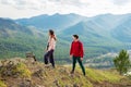 Young traveler couple stand on the top of the mountain. Man and woman hiking with backpacks on a beautiful rocky trail Royalty Free Stock Photo
