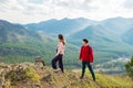 Young traveler couple stand on the top of the mountain. Man and woman hiking with backpacks on a beautiful rocky trail Royalty Free Stock Photo