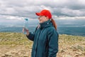 Caucasian young blonde girl drinking water from plastic bottle. mountain background.