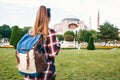 A young traveler girl with a backpack in Sultanahmet Square next to the famous Aya Sofia mosque in Istanbul in Turkey Royalty Free Stock Photo