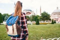 A young traveler girl with a backpack in Sultanahmet Square next to the famous Aya Sofia mosque in Istanbul in Turkey Royalty Free Stock Photo