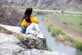 A young traveler girl sit on the top of valley. Young girl love wild life, travel, freedom. Travel Tourist Happy Woman. Travel and