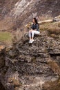 A young traveler girl sit on the top of valley. Young girl love wild life, travel, freedom. Travel Tourist Happy Woman. Travel and