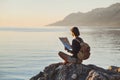 Young traveler girl sitting with map near the sea at sunset, travel, hiking and active lifestyle concept Royalty Free Stock Photo