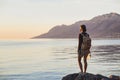 Young traveler girl standing with map near the sea at sunset, travel, hiking and active lifestyle concept Royalty Free Stock Photo