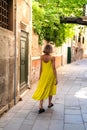 Young traveler girl on summer holidays in Europe walking on the old city street of Venice, Italy. Female back view Royalty Free Stock Photo