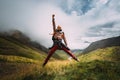 Young Traveler Man Jumping Up with His Hand Up And Smiling At Reaching The Goal. Motivation, Travel, Adventure, Achievement