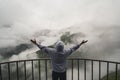 Young traveler man wearing hoodie stands on the viewpoint in national park and watching outstanding foggy landscape. Beautiful mom Royalty Free Stock Photo