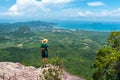 Young traveler stands on top of rock high in mountain - Dragon Crest, Krabi, Thailand