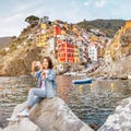 Female traveler with backpack enjoying great view on the famous landmark town Riomaggiore in Italy Royalty Free Stock Photo