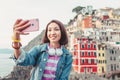 Traveler tourist woman taking selfie on her smartphone in famous old italian village Riomaggiore, Cinque Terre, Italy Royalty Free Stock Photo