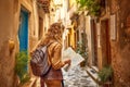 Young traveler woman alone in a narrow alley trying orientate. Travel concept