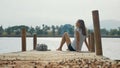 Young traveler woman sits on the wood pier and enjoying nature