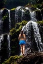 Young traveler woman at waterfall in tropical forest, Banyu Wana Amertha waterfall Wanagiri, Bali, Indonesia. View from back Royalty Free Stock Photo