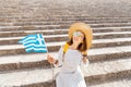 traveler woman with greek flag at the ancient greek ruins. Tourism in Greece concept Royalty Free Stock Photo