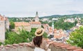 Young traveler woman in hat looking at city view of Cesky Krumlov, Czech Republic in summer