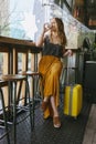 Young traveler woman with a suitcase on her coffee break Royalty Free Stock Photo