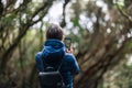 Young traveler woman taking a photo of forest landscape in Anaga Country Park Royalty Free Stock Photo