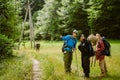 Young travelers with backpacks hiking together in forest