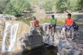 Young Travelers, hikers sits near a waterfall