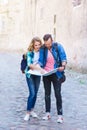 Young travelers with a tourist map. Man and woman having vacation. Backpackers, traveling and tourism concept.