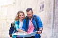 Young travelers with a tourist map. Man and woman having vacation. Backpackers, traveling and tourism concept.