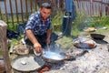 Young traveling artisan retinning old copper dish in village of Carev Dvor,Resen, Macedonia. Af