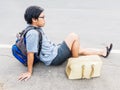 Young traveling man sit on the road