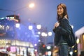 Young traveller woman walking on city street at night.