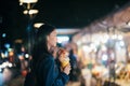 Young traveller woman walking on city street at night.