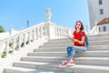 Travelling woman sitting with map on a beautiful marble stairs in old european town