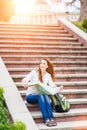 Young travelling woman sitting with map on stairs