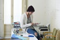 Young trendy businessman in beanie and cool hipster informal look sitting on home office desk using digital tablet pad happy Royalty Free Stock Photo